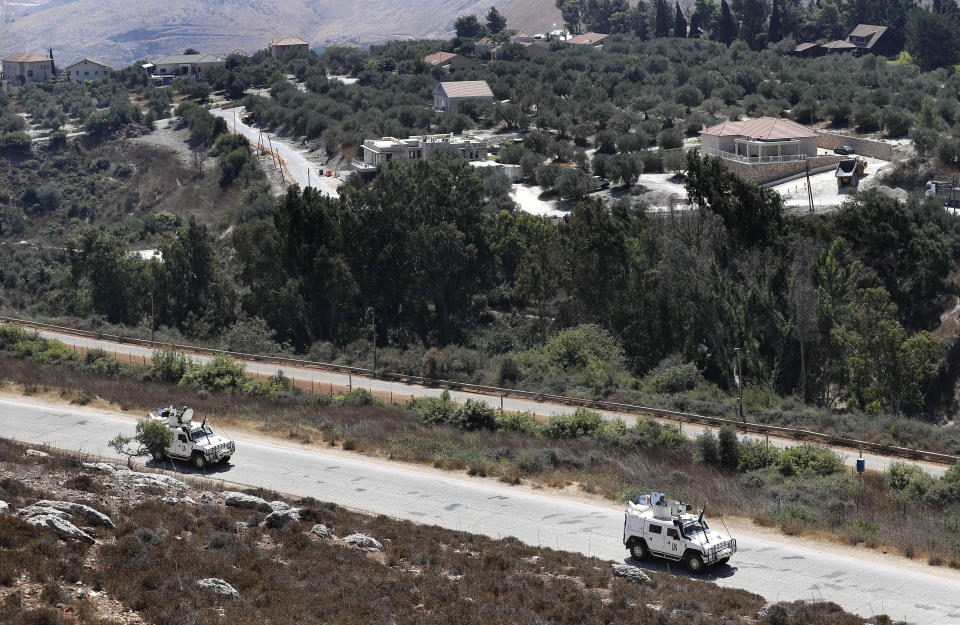Spanish UN peacekeepers patrol along the Lebanese-Israeli border, with the Israeli village of Metulla, background, in the village of Kfar Kila, Lebanon, Monday, Sept. 2, 2019. The Lebanon-Israel border was mostly calm with U.N. peacekeepers patrolling the border Monday, a day after the Lebanese militant Hezbollah group fired a barrage of anti-tank missiles into Israel, triggering Israeli artillery fire that lasted less than two hours and caused some fires. (AP Photo/Hussein Malla)