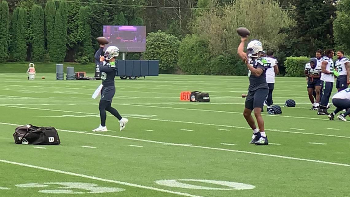 New third quarterback Jaren Hall (left) and starter Geno Smith (right) throwing before the Seahawks practice Sept. 2, 2024. They are wearing the silver helmets Seattle was to wear with 1990s throwback uniforms for its season opener Sept. 8, 2024, against the Denver Broncos at Lumen Field. Gregg Bell/The News Tribune