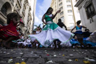 A woman dances during a rehearsal by the group "Tambores de Olokun" in Rio de Janeiro, Brazil, Sunday, April 17, 2022. The Brazilian municipalities of Rio de Janeiro and Sao Paulo postponed the traditional parades of the carnival samba schools to April 22 - 23, as a result of the COVID-19 pandemic. (AP Photo/Bruna Prado)