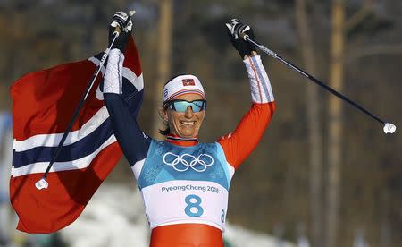 Cross-Country Skiing - Pyeongchang 2018 Winter Olympics - Women's 30km Mass Start Classic - Alpensia Cross-Country Skiing Centre - Pyeongchang, South Korea - February 25, 2018 - Gold medallist Marit Bjoergen of Norway celebrates victory with her national flag. REUTERS/Carlos Barria