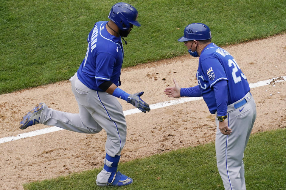 Kansas City Royals' Carlos Santana, left, rounds the bases as he celebrates with third base coach Vance Wilson after hitting a solo home run during the ninth inning of a baseball game against the Chicago White Sox in Chicago, Sunday, April 11, 2021. (AP Photo/Nam Y. Huh)