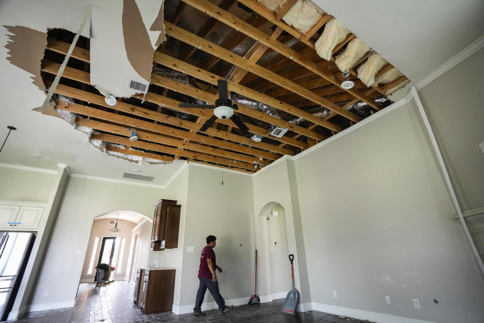 A restoration crew works in a home while cleaning up storm damage, Sunday, May 19, 2024, in Cypress, Texas. (Brett Coomer/Houston Chronicle via AP)