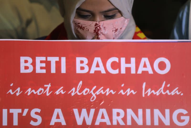 A woman holds a placard during a protest after the death of a rape victim, on a street in Mumbai