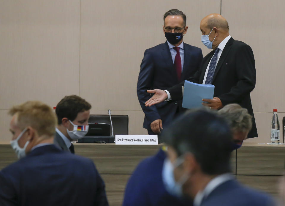 German Foreign Minister Heiko Maas, left, and French Foreign Minister Jean-Yves Le Drian wearing masks arrives for the opening session of the French ambassadors to European countries in Paris, Monday, Aug. 31, 2020. (AP Photo/Michel Euler)