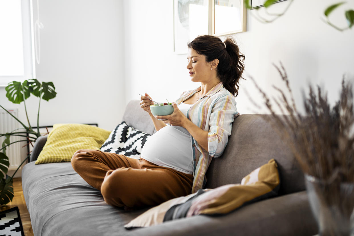 Young pregnant pregnancy woman eating fresh salad