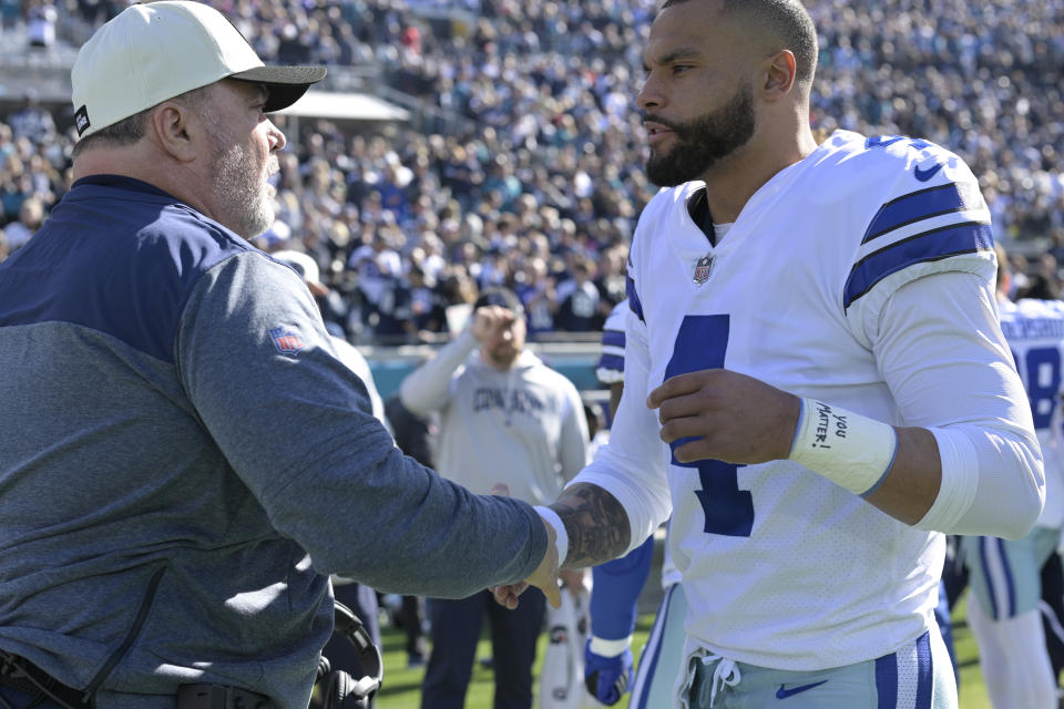 Dallas Cowboys head coach Mike McCarthy, left, and quarterback Dak Prescott (4) shake hands prior to the start of an NFL football game against the Jacksonville Jaguars, Sunday, Dec. 18, 2022, in Jacksonville, Fla. (AP Photo/Phelan M. Ebenhack)