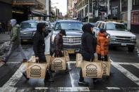 Employees carry delivery bags full of food out of a Shake Shack store in New York January 30, 2015. REUTERS/Lucas Jackson