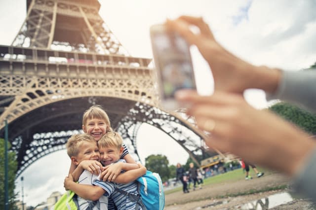 Kids tourists smiling at the camera near Eiffel Tower