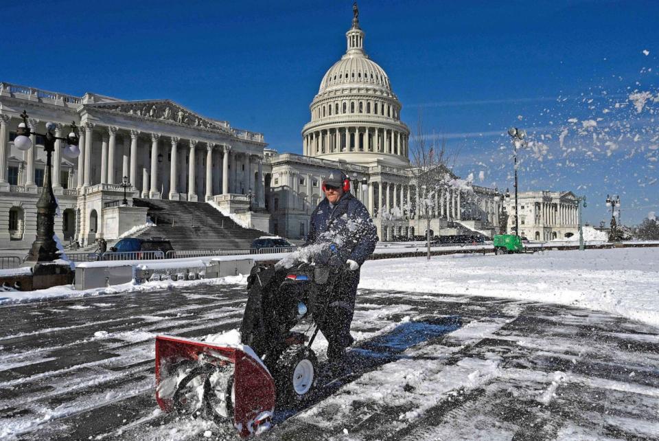 PHOTO: Workers remove snow from the East Front of the US Capitol on Jan. 4, 2022 in Washington, D.C., on the day after a heavy snowstorm.  (Olivier Douliery/AFP via Getty Images)