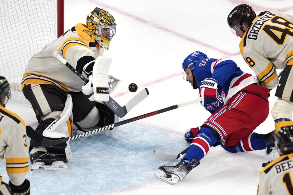 Boston Bruins goaltender Jeremy Swayman, left, makes a save on a shot by New York Rangers center Vincent Trocheck, right, during the first period of an NHL hockey game, Saturday, Dec. 16, 2023, in Boston. (AP Photo/Charles Krupa)