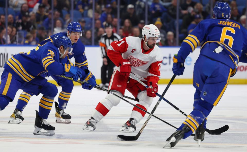 Detroit Red Wings center Dylan Larkin carries the puck as Buffalo Sabres defenseman Connor Clifton defends during the first period at KeyBank Center in Buffalo on Dec. 5, 2023.