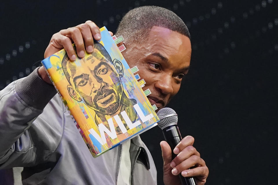 Will Smith sostiene un ejemplar de su libro de memorias "Will" durante un evento de promoción en Filadelfia, el lunes 8 de noviembre de 2021. (AP Foto/Matt Rourke)