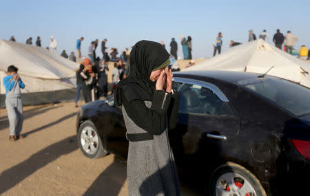 Palestinians react after inhaling tear gas fired by Israeli troops during clashes at the Gaza-Israel border at a protest demanding the right to return to their homeland, in the southern Gaza Strip March 31, 2018. REUTERS/Ibraheem Abu Mustafa