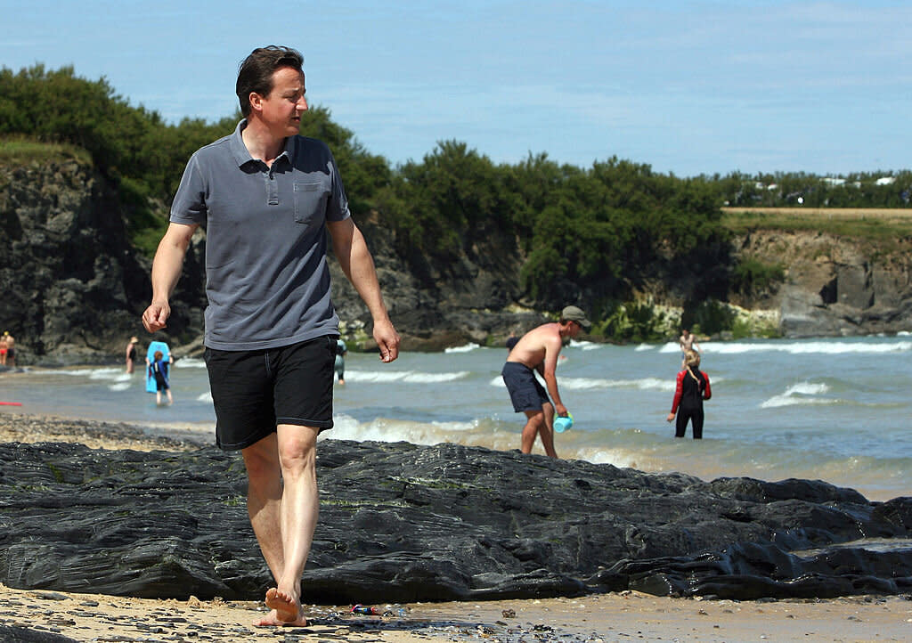 PADSTOW, UNITED KINGDOM - JULY 27:  David Cameron walks on the beach at Harlyn Bay on July 27, 2008 in Harlyn near Padstow, England. David Cameron, leader of the opposition the Conservative party, is currently enjoying a huge lead in the polls, is currently on holiday in the area with his family. The Prime Minister, Gordon Brown, has chosen to take his annual holiday in Southwold, Suffolk.  (Photo by Matt Cardy/Getty Images)