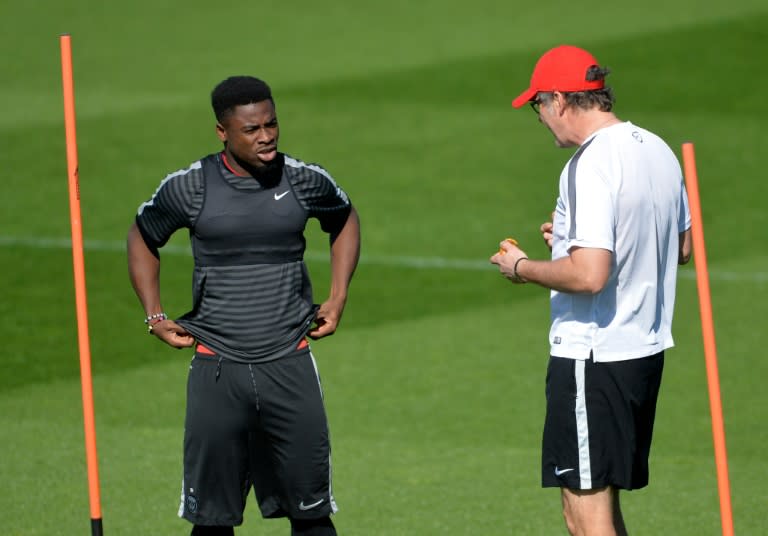 Paris Saint-Germain's head coach Laurent Blanc (R) talks to defender Serge Aurier before a training session on April 14, 2015 at the Camp des Loges in Saint-Germain-en-Laye, west of Paris