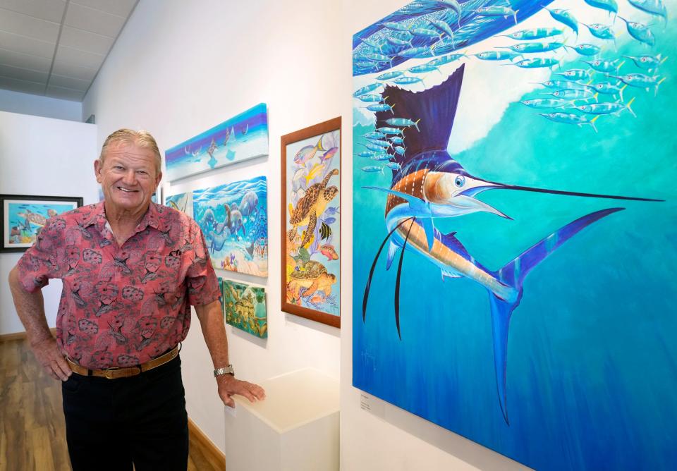 Guy Harvey poses with one of his pieces at Gallery500 at One Daytona Beach in Daytona Beach. “We’re working with kids and in schools to make sure the next generation cares about protecting our waters.”