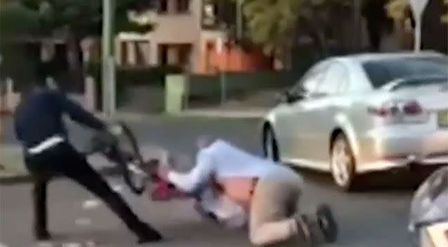 Things get ugly as the cyclist is dragged along the ground. Source: 7 News