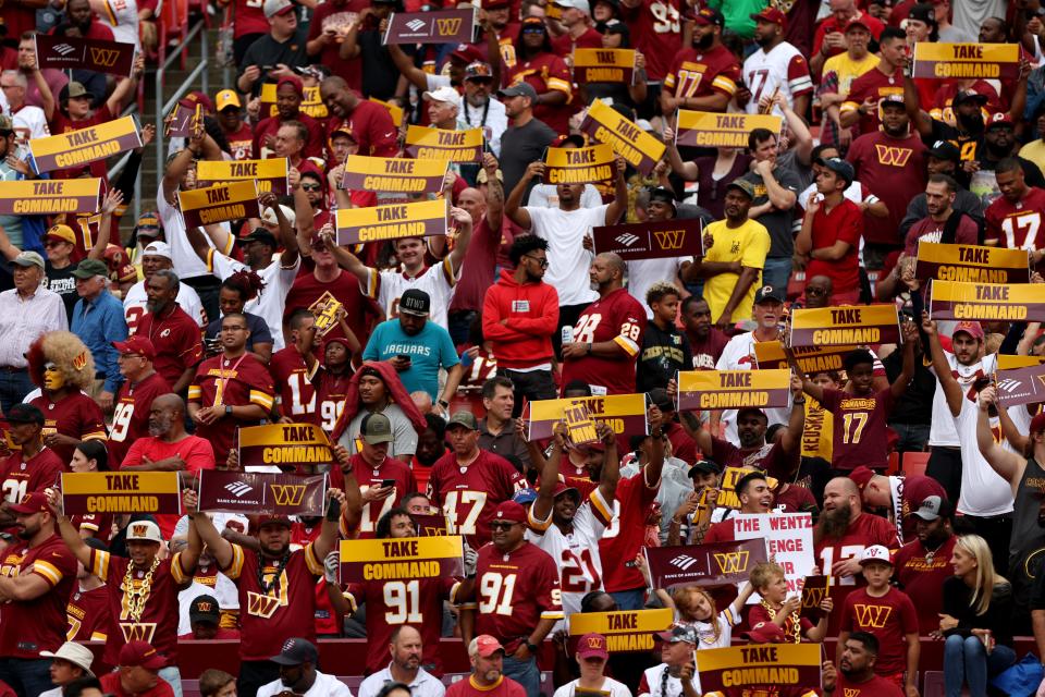 Fans hold up signs during the Washington Commanders and Jacksonville Jaguars game at FedExField on September 11, 2022.