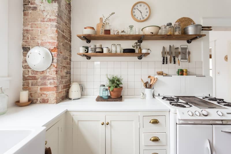 White kitchen with rustic wood accents and brick pillars