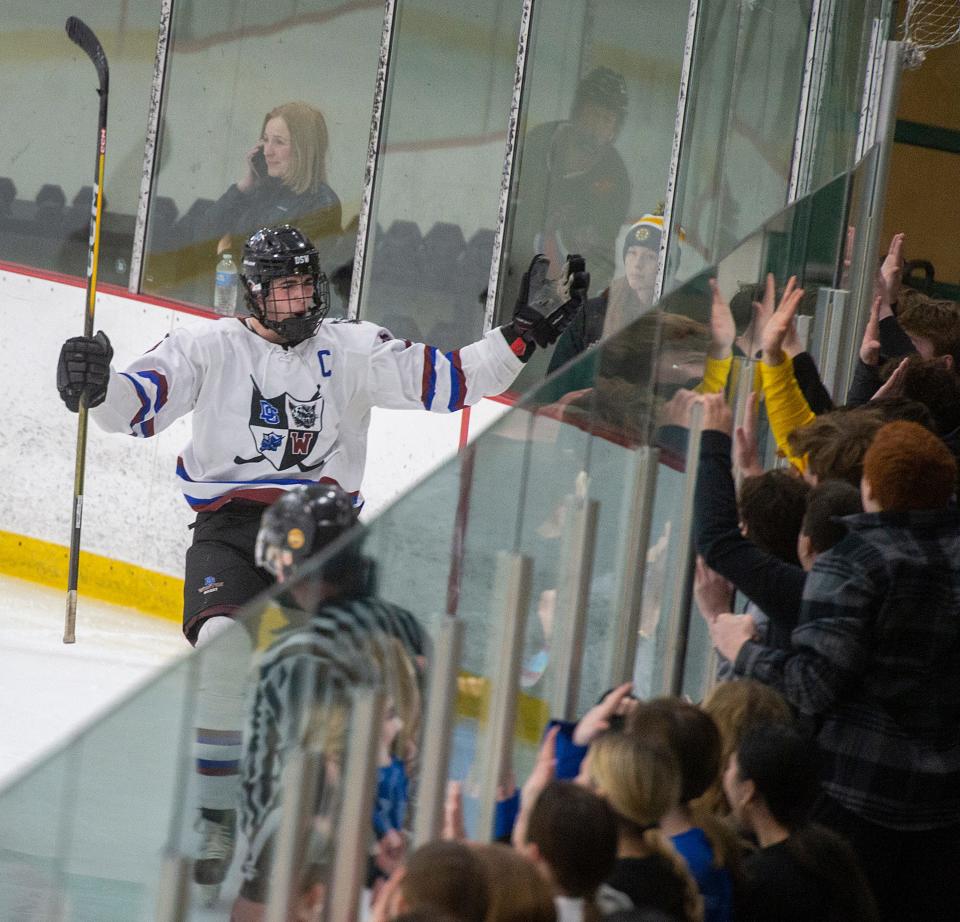 Dover-Sherborn Weston boys hockey senior captain Sawyer Garzone celebrates a goal with student fans against Hopedale at the MacDowell Arena at Rivers, Feb. 12, 2024.