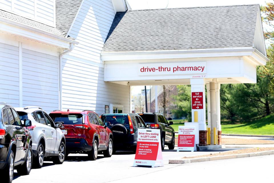 People wait in a drive-thru line at a CVS store to take COVID tests.