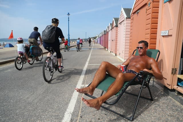 Stuart (no surname given) soaks up some rays outside a beach hut at Bournemouth on August 8 