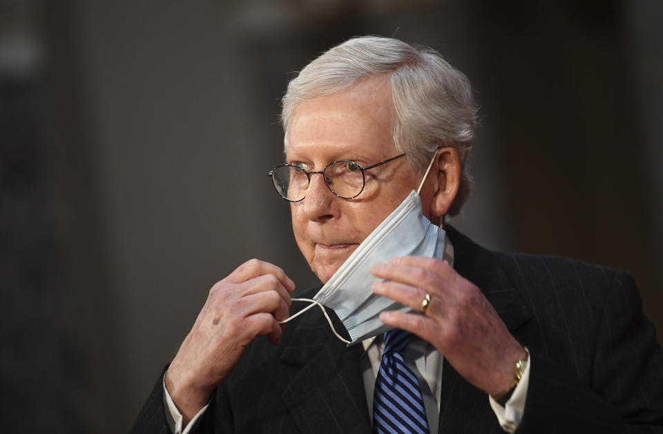 Mitch McConnell adjusts his face mask as he participates in a swearing-in reenactment ceremony in the Old Senate Chamber at the Capitol in Washington. Source: AAP