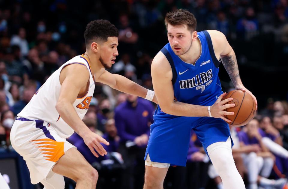 Jan 20, 2022; Dallas, Texas, USA; Dallas Mavericks guard Luka Doncic (77) looks to score as Phoenix Suns guard Devin Booker (1) defends during the second half at American Airlines Center. Mandatory Credit: Kevin Jairaj-USA TODAY Sports