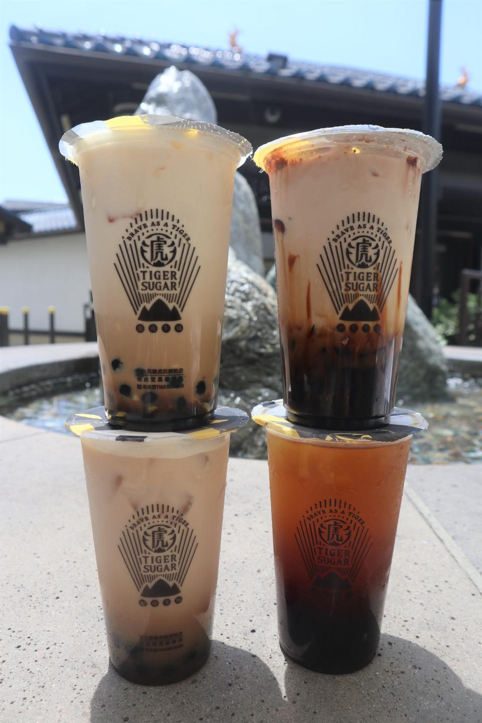 A black tea latte with cream mousse, chocolate malt with tiger jelly, black sugar mochi bobo and oolong tea from bubble tea chain Tiger Sugar.