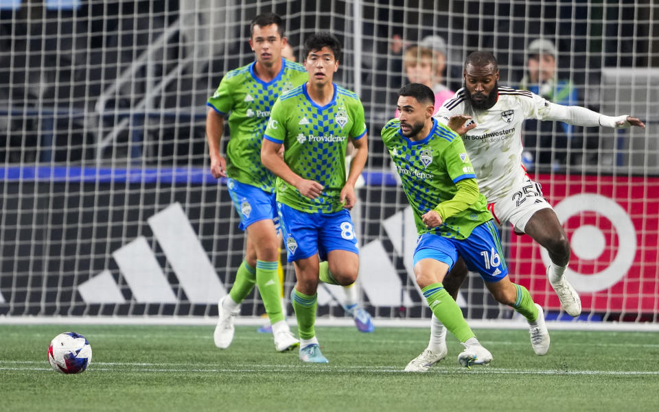 Seattle Sounders midfielder Alex Roldan (16) clears the ball away from FC Dallas defender Sebastien Ibeagha (25) during the first half of an MLS playoff soccer match Monday, Oct. 30, 2023, in Seattle. (AP Photo/Lindsey Wasson)