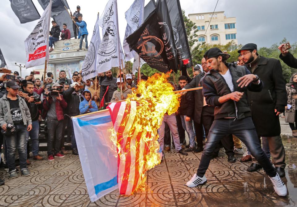 <p>Palestinian protesters burn the U.S. and Israeli flags in Gaza City on Dec. 6, 2017. (Photo: Mahmud Hams/AFP/Getty Images) </p>