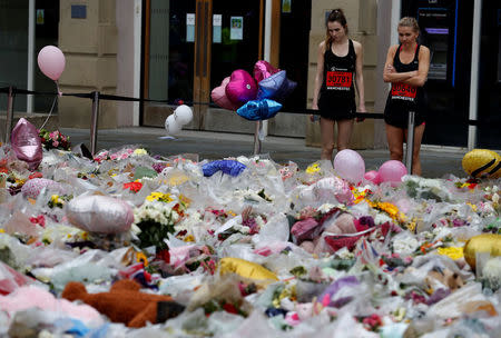 Runners competing in the Great Manchester Run look at floral tributes for the victims of the Manchester Arena attack, in St Ann's Square, in central Manchester, Britain May 28, 2017. REUTERS/Phil Noble