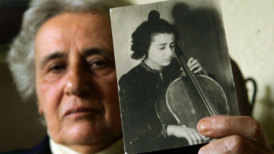 Holocaust survivor Anita Lasker-Wallfisch holds up a portrait of herself playing the cello taken in Berlin before WWII during an interview before the 60th anniversary of the liberation of Auschwitz 18 January 2005 in London. - Jim Watson/AFP/Getty Images