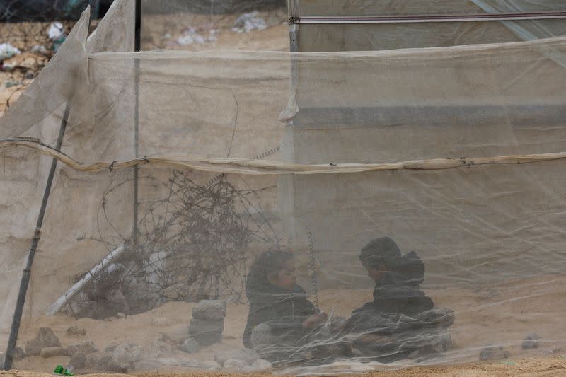 Palestinian sit in a tent as they shelter at the border with Egypt, amid fears of an exodus of Palestinians into Egypt, as the conflict between Israel and Hamas continues, in Rafah southern Gaza Strip