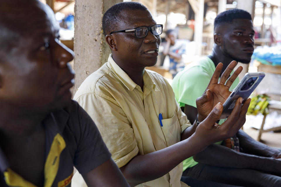 A man asks questions during a mobile app training session at the market in Hohoe, Ghana, Wednesday, April 18, 2024. Internet-enabled phones can play a unique role in sub-Saharan Africa, where infrastructure and public services are among the world’s least developed. But despite growing mobile internet coverage on the continent of 1.3 billion people, just 25% of adults in sub-Saharan Africa currently have access to it. (AP Photo/ Misper Apawu)