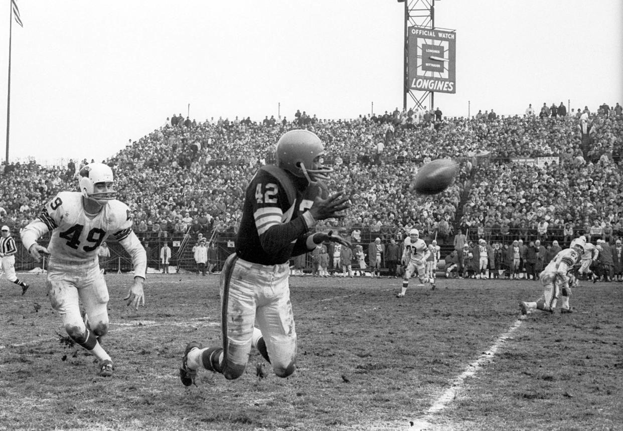 Browns receiver Paul Warfield catches a pass in front of St. Louis Cardinals defensive back Jimmy Burson (49) at Busch Stadium, Dec. 6, 1964.