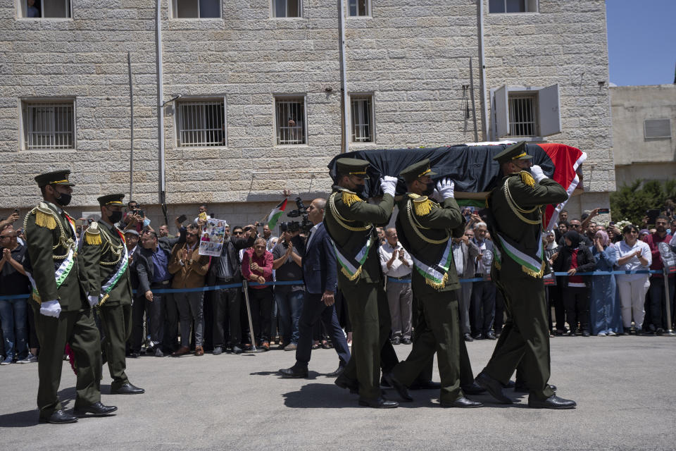 A Palestinian honor guard carry the body of slain Al Jazeera journalist Shireen Abu Akleh, who was shot dead Wednesday during an Israeli military raid in the West Bank city of Jenin, during an official ceremony at the Palestinian Authority headquarters in Ramallah, Thursday, May 12, 2022. Thousands gathered to mourn Abu Akleh in the occupied West Bank city of Ramallah on Thursday, as the head of the Palestinian Authority blamed Israel for her death and rejected Israeli calls for a joint investigation. (AP Photo/Nasser Nasser)