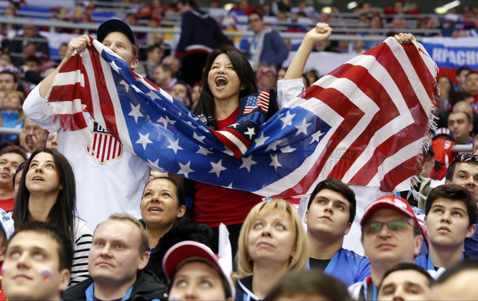 US fans cheer a second period goal by the USA against Russia during a men's ice hockey game at the 2014 Winter Olympics, Saturday, Feb. 15, 2014, in Sochi, Russia. (AP Photo/Mark Humphrey)