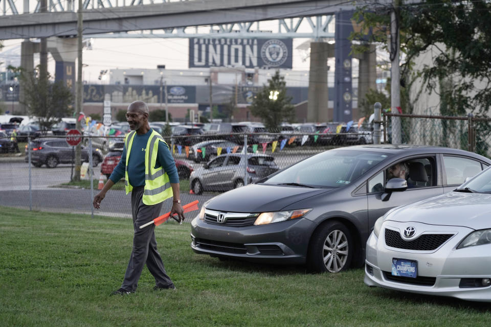 Reginald Rawls directs a car into a spot at the Calvary Baptist Church parking lot which is located near the Philadelphia Union's Subaru Park, Wednesday, Oct. 4, 2023, in Chester, Pa. Like many other Black Protestant churches, Calvary Baptist struggled economically during the coronavirus pandemic. Attendance numbers fell, and along with it, funding. But the church has transformed its parking lot into game-day fundraisers, with volunteers from the congregation staffing the lots and selling spaces for $15 per vehicle. (AP Photo/Michael Perez)