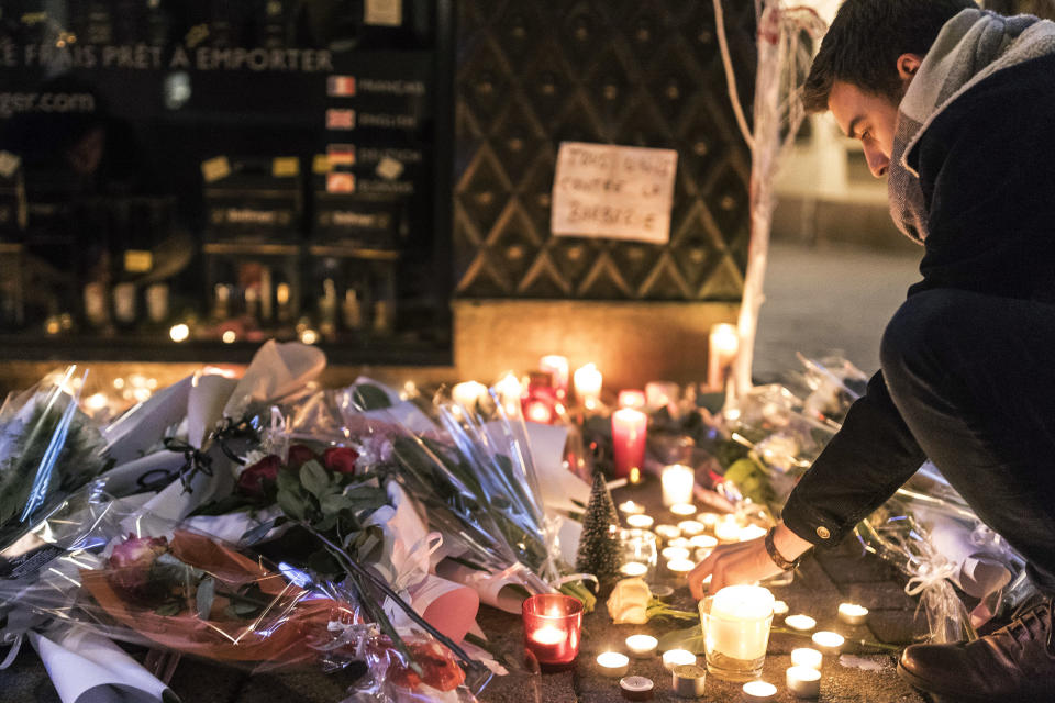 Un hombre enciende una vela en señal de respeto por las víctimas una noche después de un ataque en el que murieron 3 personas y al menos otras 13 resultaron heridas en Estrasburgo, en el este de Francia, el miércoles 12 de diciembre de 2018. (AP Foto/Jean Francois Badias)