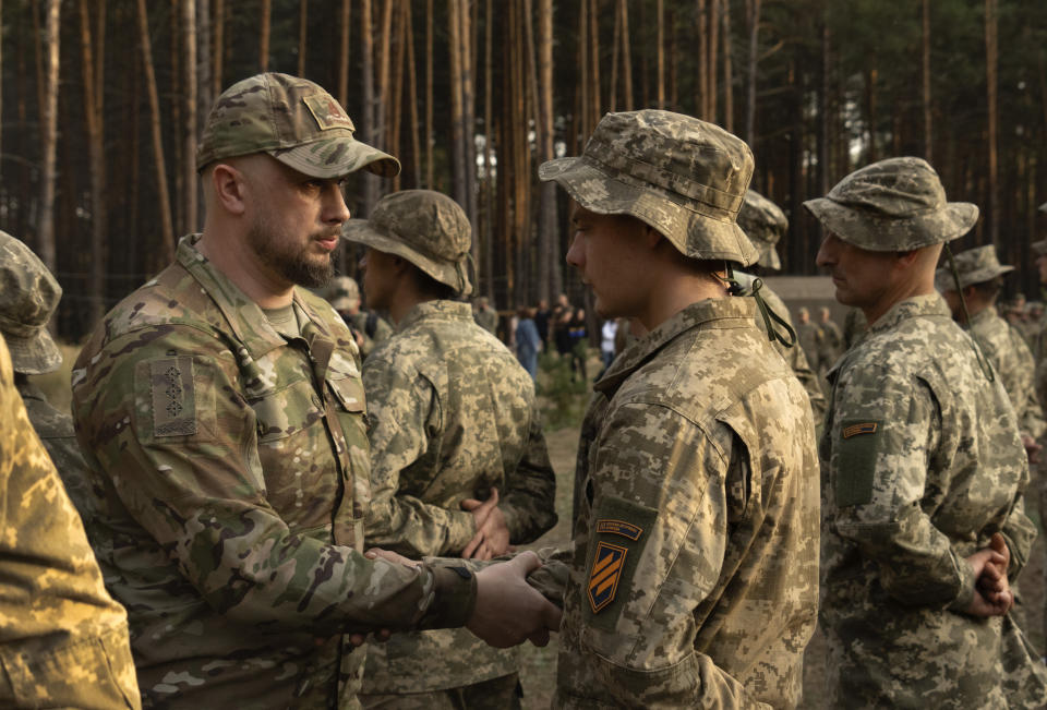Commander of Ukraine's 3rd Assault Brigade Andriy Biletsky, left, shakes hands with newly recruited soldiers at a military base close to Kyiv, Ukraine, Monday, Sept. 25, 2023. The loss of the city of Avdiivka in February, 2024 marked the end of a long, exhausting defense for the Ukrainian military. One brigade had defended the same block of buildings for months without a break. (AP Photo/Efrem Lukatsky)