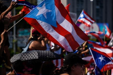 Demonstrators wave Puerto Rican flags during the National Strike calling for the resignation of Governor Ricardo Rossello in San Juan