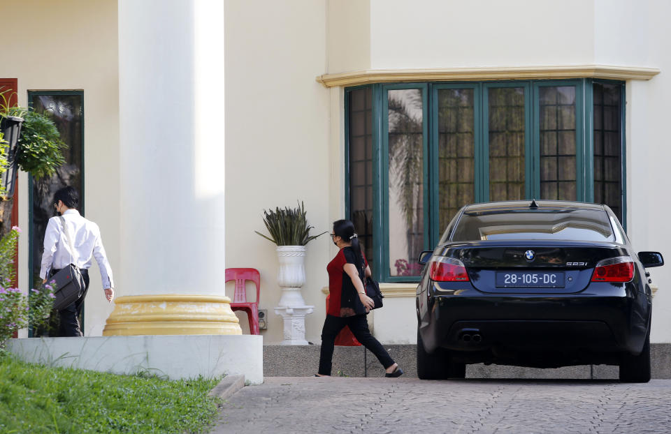 Unidentified persons get out of a car at the North Korean Embassy in Kuala Lumpur, Malaysia, Saturday, March 20, 2021. Malaysia said Friday it will order all North Korean diplomats to leave the country within 48 hours, an escalation of diplomat brawl over Malaysia's move to extradite a North Korean suspect to the United States for money laundering charges. (AP Photo/Lai Seng Sin)