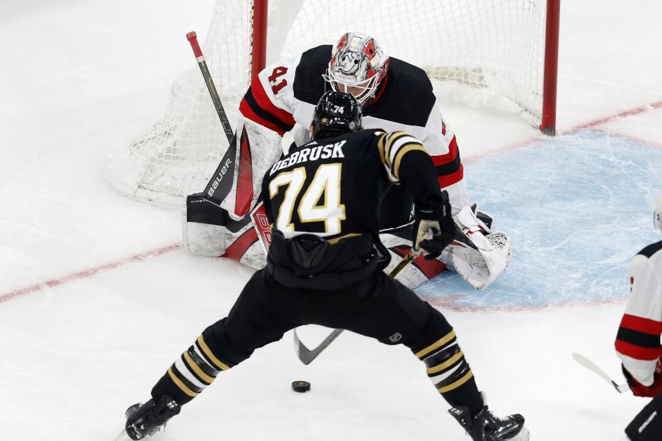 Boston Bruins' Jake DeBrusk (74) sets up to score on New Jersey Devils' Vitek Vanecek (41) during the second period of an NHL hockey game Saturday, Dec. 30, 2023, in Boston. (AP Photo/Michael Dwyer)