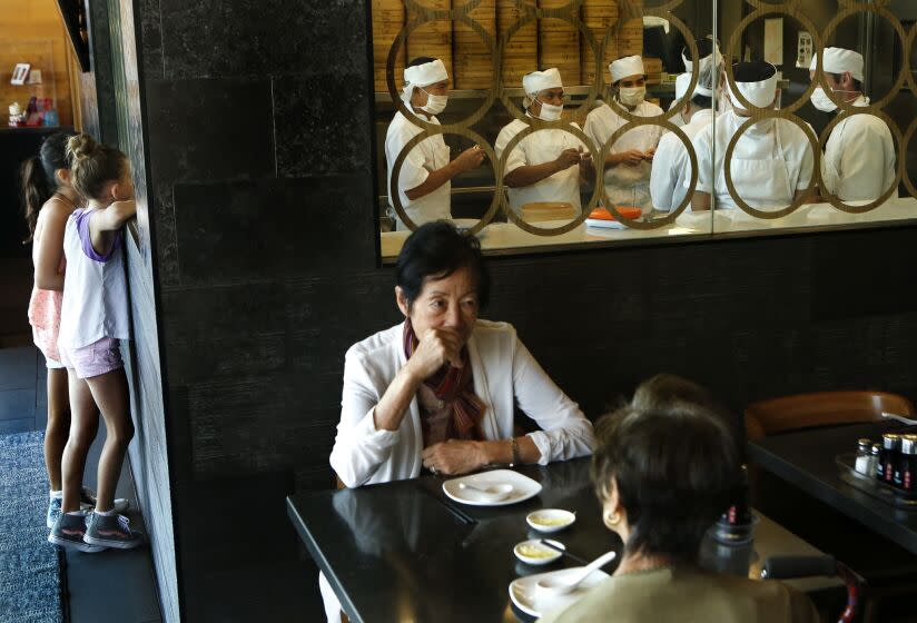 Chefs, background, prepare dumplings at Din Tai Fung,