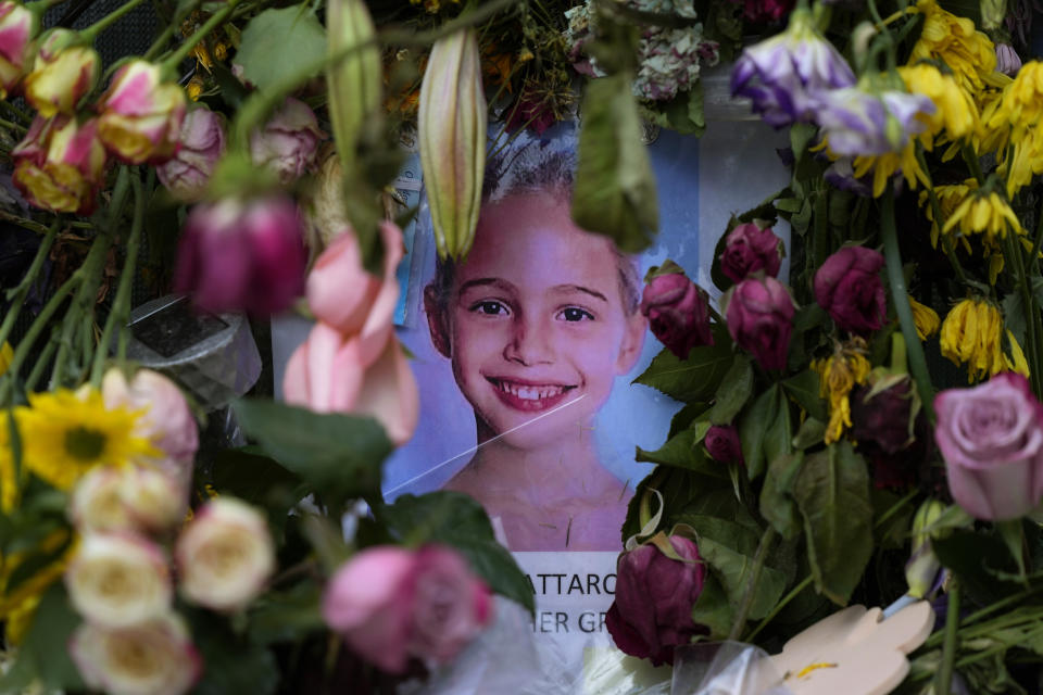 Flowers from well-wishers surround a photograph of Stella Cattarossi, age 7, on a makeshift memorial wall for the victims of the Champlain Towers South building collapse, on Monday, July 12, 2021, in Surfside, Fla. (AP Photo/Rebecca Blackwell)