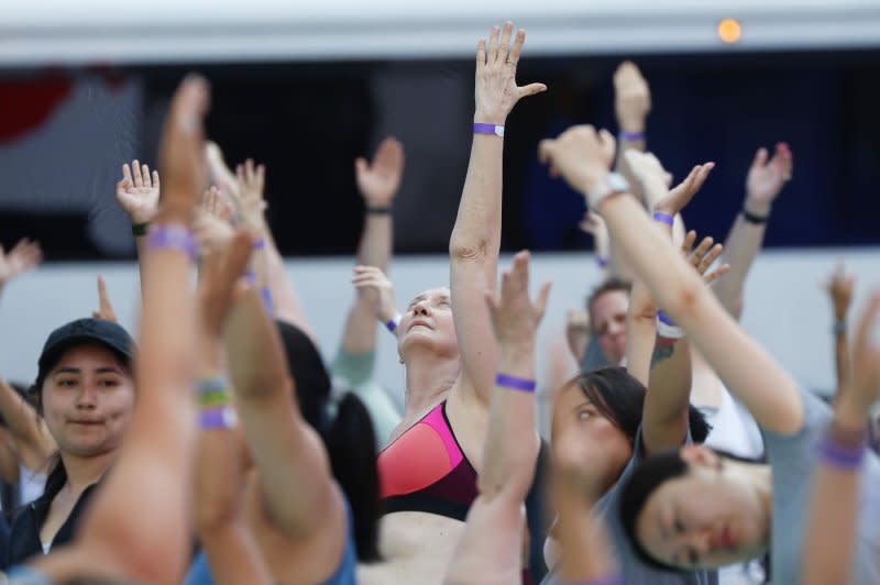 People attend a yoga class in celebration of the summer solstice at the 22nd annual all-day outdoor yoga event in Times Square in New York on Thursday. Photo by John Angelillo/UPI