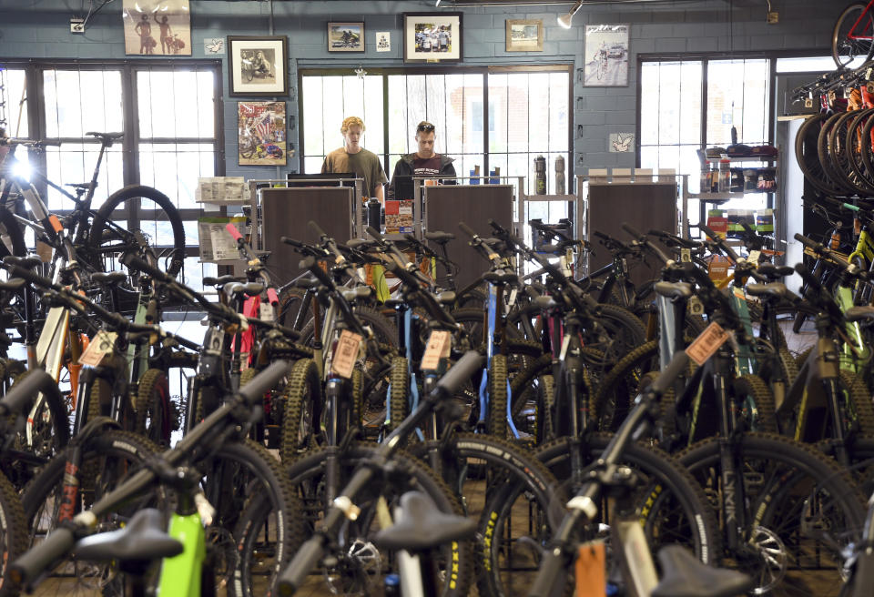 Salesmen Will Malfeld, left, and Ben Chandler, right, work at University Bicycles in Boulder, Colo., Tuesday, April 30, 2024. Bike stores quickly sold out of their stock early in the pandemic and had trouble restocking because of supply chain issues. Now, inventory is back, but demand has waned. (AP Photo/Thomas Peipert)