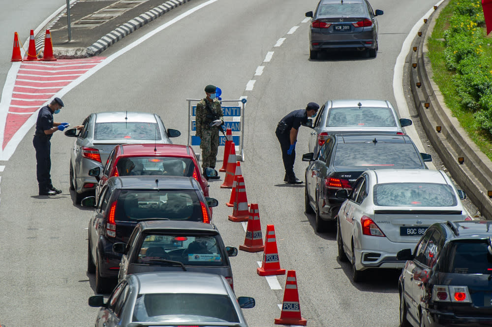 Police officers conducting checks at a roadblock in Jalan Kuching, Kuala Lumpur January 31, 2021. PH’s Economic Committee first said the government must put a stop to the implementation of repeated lockdowns and subsequent confusion triggered by ever-changing standard operating procedures (SOPs). — Picture by Shafwan Zaidon