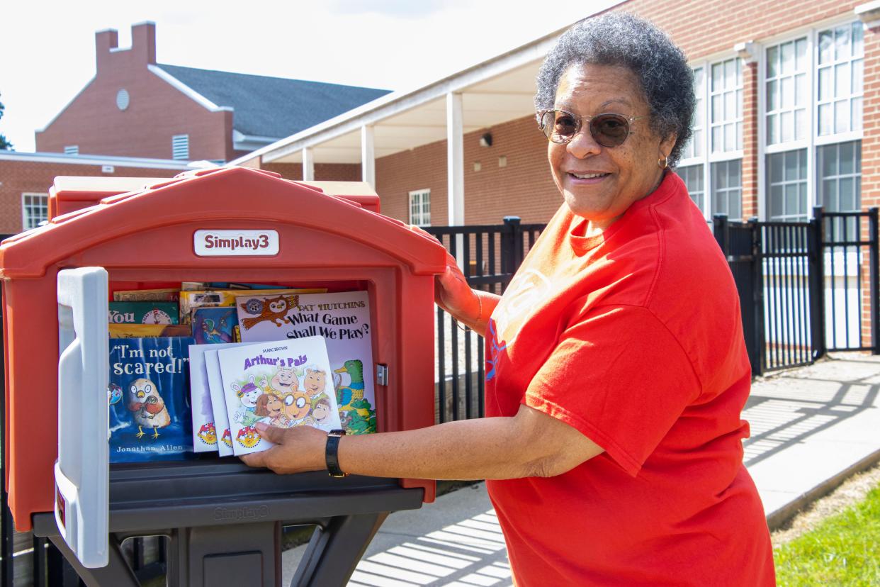 Elayne Dunlap adds books to the Little Free Library that Alliance City Schools installed in Dunlap's honor at Alliance Preschool. Dunlap, currently a member of the Alliance City Schools Board of Education, was a teacher in the school district for more than 30 years.